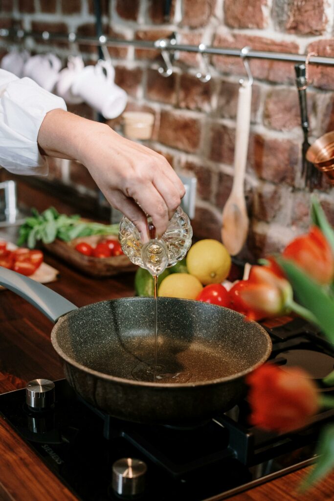 A close-up of home cooking with fresh ingredients being added to a pan in a cozy kitchen setting.